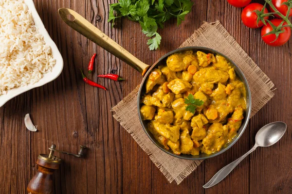 Körili tavuk sosu. Tavada servis edilmiş. Üst Manzara. Doğal ahşap zemin.