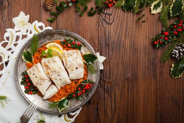 Noel balığı. Kızarmış morina parçaları, sebze sosunda servis edilir. Xmas stili. Üst görünüm.