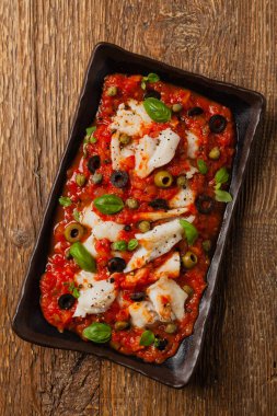 İtalyan usulü morina, domatesli zeytin ve kapari. Üst görünüm.