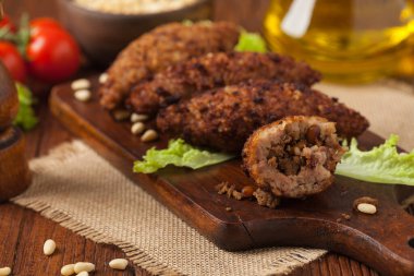 Geleneksel Arap kibbesi, kuzu ve çam fıstığı. Ön manzara. Doğal ahşap zemin.