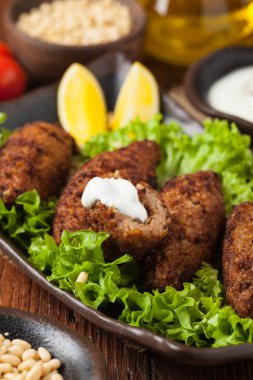 Geleneksel Arap kibbesi, kuzu ve çam fıstığı. Ön manzara. Doğal ahşap zemin.