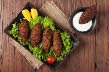 Geleneksel Arap kibbesi, kuzu ve çam fıstığı. Üst Manzara. Doğal ahşap zemin.