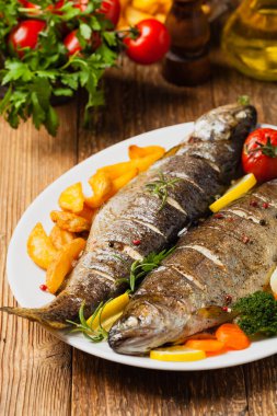 Izgara alabalık. Fırında patatesle servis edilir. Ön görünüm. 