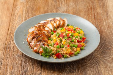 Teriyaki soslu ızgara tavuk göğsü. Kahverengi pirinç ve sebzelerle servis edilir. Ön görünüm. 