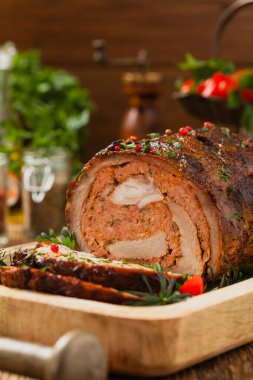 Bütün olarak kızartılmış, kıymalı domuz boynuyla doldurulmuş. Ön manzara. Doğal ahşap zemin.