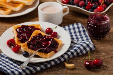 Kahvaltıda. Kirazlı tost, şeftali reçeli ve taze meyve. Ön görünüm. 