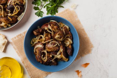 Kızarmış tavuk ciğeri ve soğan. Üst Manzara. Taş arkaplan.