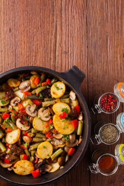 Kızarmış tava sebze, mantarlı ve kurutulmuş domatesli. Baharatlı bitki karışımı.