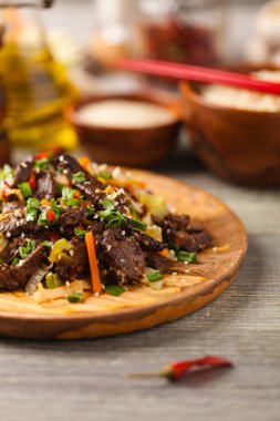 Geleneksel Kore Bulgogi yemeği. İnce dilimlenmiş, ızgara sığır eti, pirinç ve sebzelerle servis edilmiş. Ön manzara. Doğal ahşap zemin.