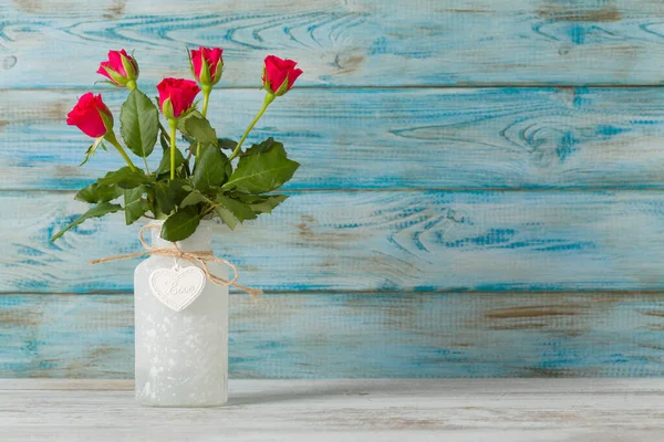 情人节 蓝色木制背景花瓶里的玫瑰 — 图库照片