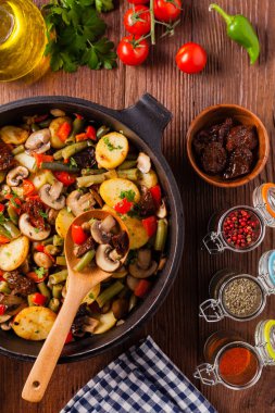 Kızarmış tava sebze, mantarlı ve kurutulmuş domatesli. Baharatlı bitki karışımı.