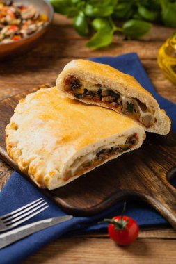 Mantarlı ve jambonlu İtalyan calzone. Ön görünüm. 