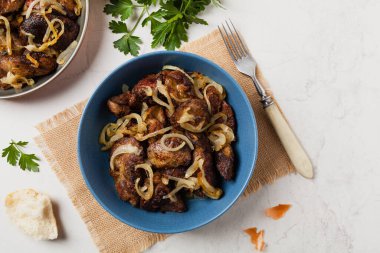 Kızarmış tavuk ciğeri ve soğan. Üst Manzara. Taş arkaplan.