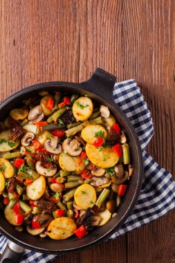 Kızarmış tava sebze, mantarlı ve kurutulmuş domatesli. Baharatlı bitki karışımı.