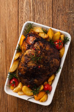 Patates, biber ve domatesle omuz omuza kavrulmuş. Beyaz şarapla marine edilmiş. Manzaralı. Doğal ahşap zemin. 