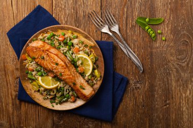 Asya yemeği. Pirinç ve sebzeli kızarmış somon. Susam tohumları serpiştirilmiş. Üst Manzara. Doğal arkaplan. 