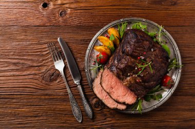 Kızarmış göğüs eti. Kırsal tarzda, doğal ahşap arka plan. Karanlık stil. Üst Manzara. Düz yatıyordu. 