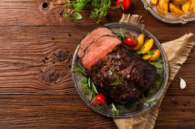 Kızarmış göğüs eti. Kırsal tarzda, doğal ahşap arka plan. Karanlık stil. Üst Manzara. Düz yatıyordu. 