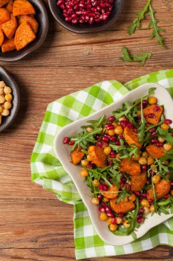 Mercimek, nar ve roketli tatlı patates salatası. Üst Manzara. Doğal ahşap zemin.