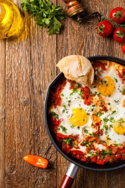 Shakshouka, domates sosunda haşlanmış yumurta, acı biber, soğan. Üst görünüm. 
