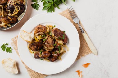 Kızarmış tavuk ciğeri ve soğan. Üst Manzara. Taş arkaplan.