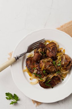 Kızarmış tavuk ciğeri ve soğan. Üst Manzara. Taş arkaplan.