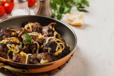 Kızarmış tavuk ciğeri ve soğan. Ön manzara. Taş arkaplan.