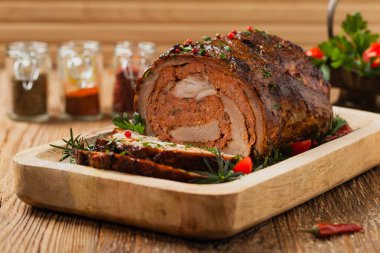 Bütün olarak kızartılmış, kıymalı domuz boynuyla doldurulmuş. Ön manzara. Doğal ahşap zemin.