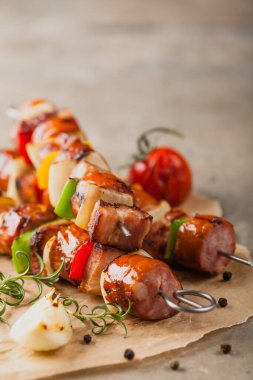 Sosisli, pastırmalı ve sebzeli ızgara şiş. Ön manzara. taş arkaplan. 