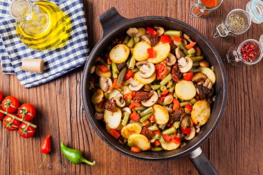 Kızarmış tava sebze, mantarlı ve kurutulmuş domatesli. Baharatlı bitki karışımı.