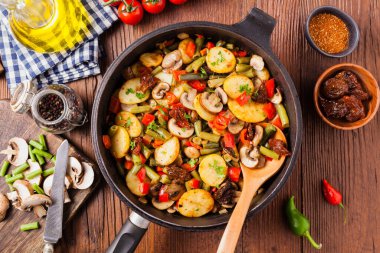 Kızarmış tava sebze, mantarlı ve kurutulmuş domatesli. Baharatlı bitki karışımı.