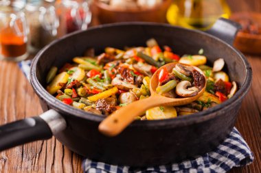 Kızarmış tava sebze, mantarlı ve kurutulmuş domatesli. Baharatlı bitki karışımı.