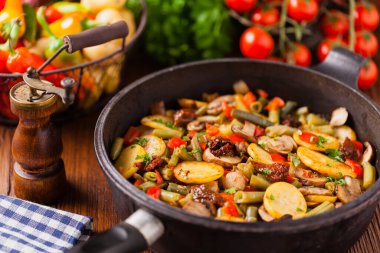 Kızarmış tava sebze, mantarlı ve kurutulmuş domatesli. Baharatlı bitki karışımı.