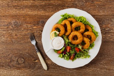 Kızarmış kalamar halkaları ve salata. Üst görünüm.