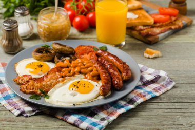 Tam İngiliz kahvaltısı, sosis, mantar, fasulye ve sahanda yumurta. Ön görünüm. 