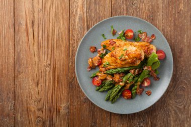 Kızarmış tavuk göğsü, kuşkonmazla servis edilen domates sosu, kurutulmuş domates. Üst görünüm.