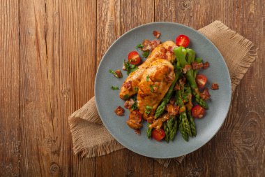 Kızarmış tavuk göğsü, kuşkonmazla servis edilen domates sosu, kurutulmuş domates. Üst görünüm.