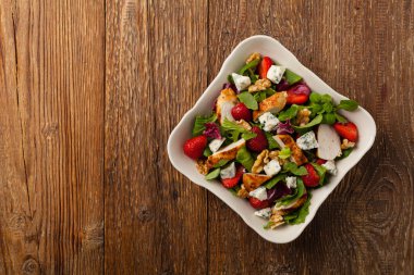 Kızarmış tavuk, mavi peynir, çilek ve cevizli lezzetli salata. Üst görünüm. 