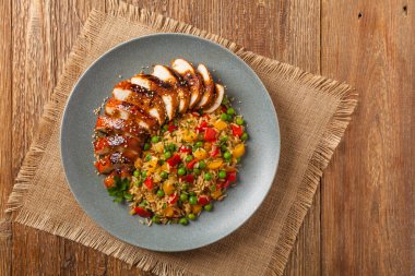 Teriyaki soslu ızgara tavuk göğsü. Kahverengi pirinç ve sebzelerle servis edilir. Üst Manzara. Düz yatıyordu.