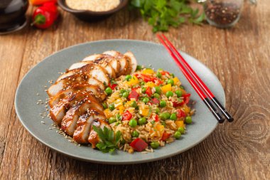 Teriyaki soslu ızgara tavuk göğsü. Kahverengi pirinç ve sebzelerle servis edilir. Ön görünüm. 