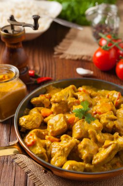 Körili tavuk sosu. Tavada servis edilmiş. Ön manzara. Doğal ahşap zemin.