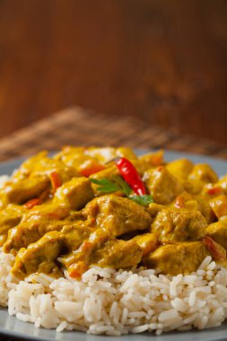 Körili tavuk sosu. Pirinçle servis edilmiş. Ön manzara. Doğal ahşap zemin.