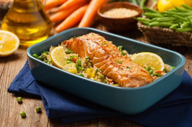 Asya yemeği. Pirinç ve sebzeli kızarmış somon. Susam tohumları serpiştirilmiş. Ön manzara. Doğal arkaplan. 