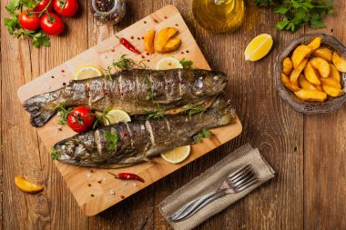 Izgara alabalık. Fırında patatesle servis edilir. Üst görünüm. 