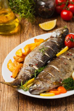 Izgara alabalık. Fırında patatesle servis edilir. Ön görünüm. 