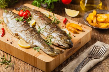 Izgara alabalık. Fırında patatesle servis edilir. Ön görünüm. 