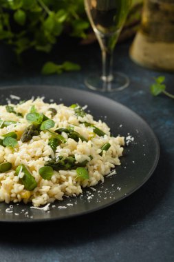 Klasik İtalyan pilavı ve kuşkonmaz. Ön manzara. Koyu mavi arkaplan.