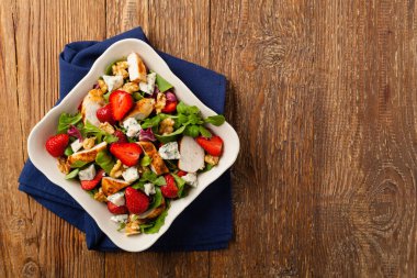 Kızarmış tavuk, mavi peynir, çilek ve cevizli lezzetli salata. Üst görünüm. 