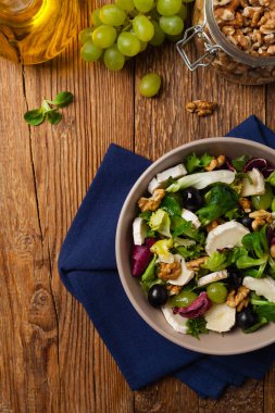 Keçi peynirli, üzümlü ve cevizli İtalyan bahar salatası. Kızarmış ekmekle servis edilir. Üst görünüm. 
