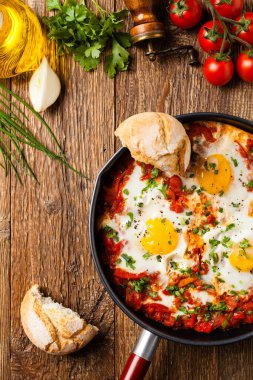 Shakshouka, domates sosunda haşlanmış yumurta, acı biber, soğan. Üst görünüm. 